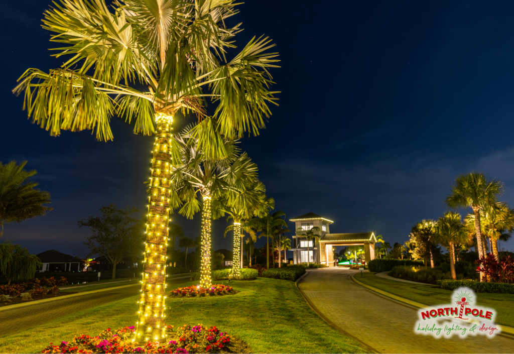 HOA entrance holiday lighting setup at a community in Port St. Lucie, featuring illuminated monument signs, lit palm trees, and roofline outlines.