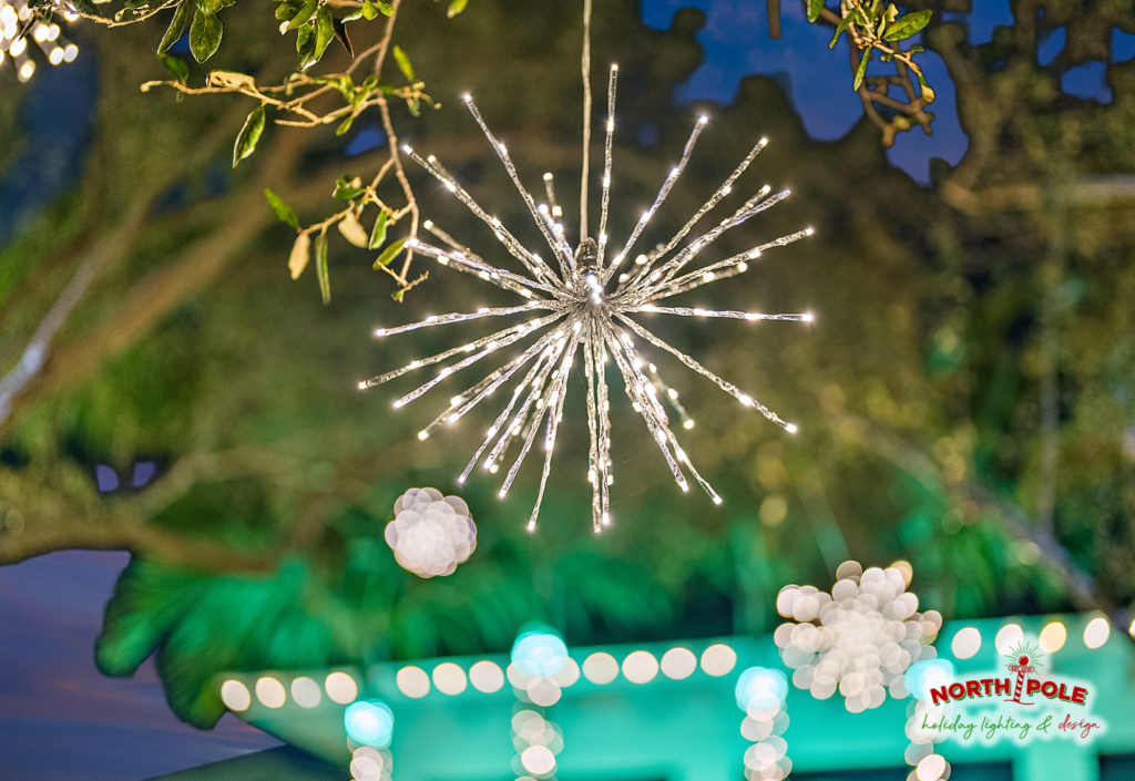 Large hanging LED starburst light display in a canopy tree at a Jonathan's Landing estate in Jupiter, FL.