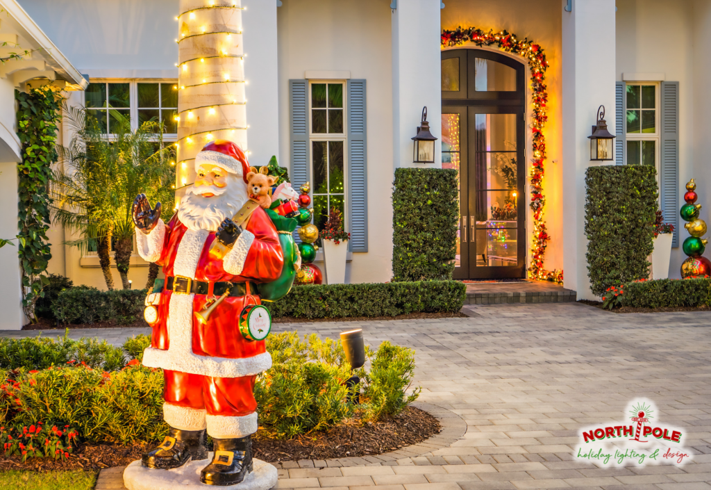 Luxury holiday lighting at Mirasol Country Club featuring warm white LED tree wraps, lit garland, and custom decor pieces.