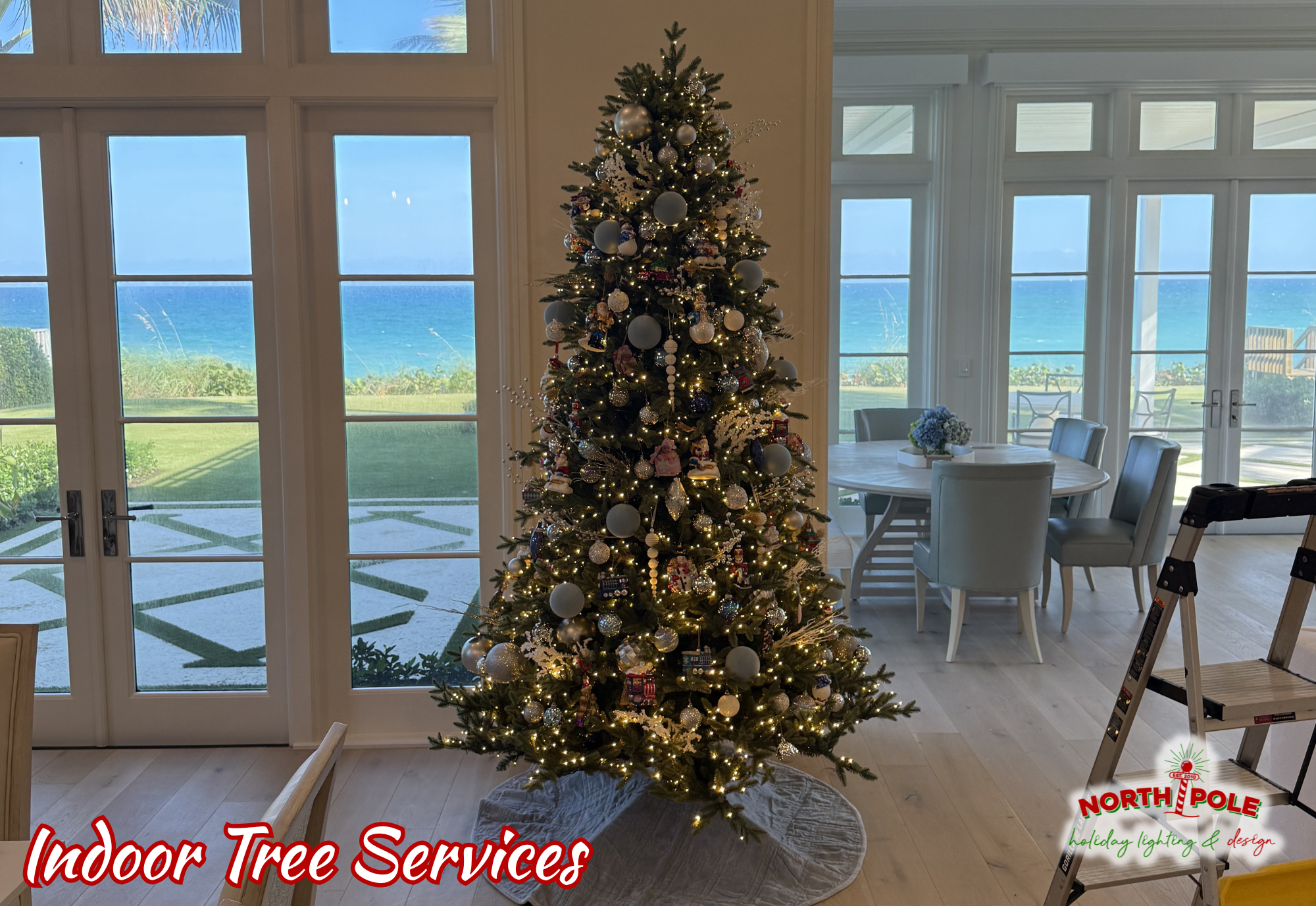 Professional indoor Christmas tree decorating service in a luxury Boca Raton home featuring gold and silver ornaments.