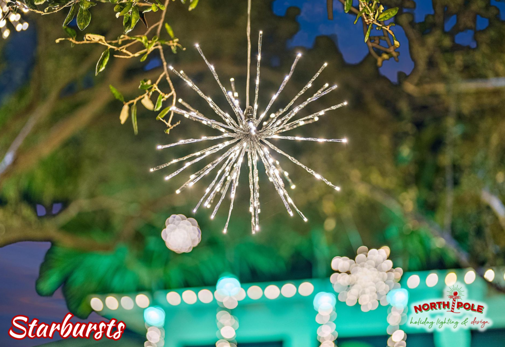 Modern LED starburst holiday light fixtures hanging from a landscape tree in Jensen Beach.