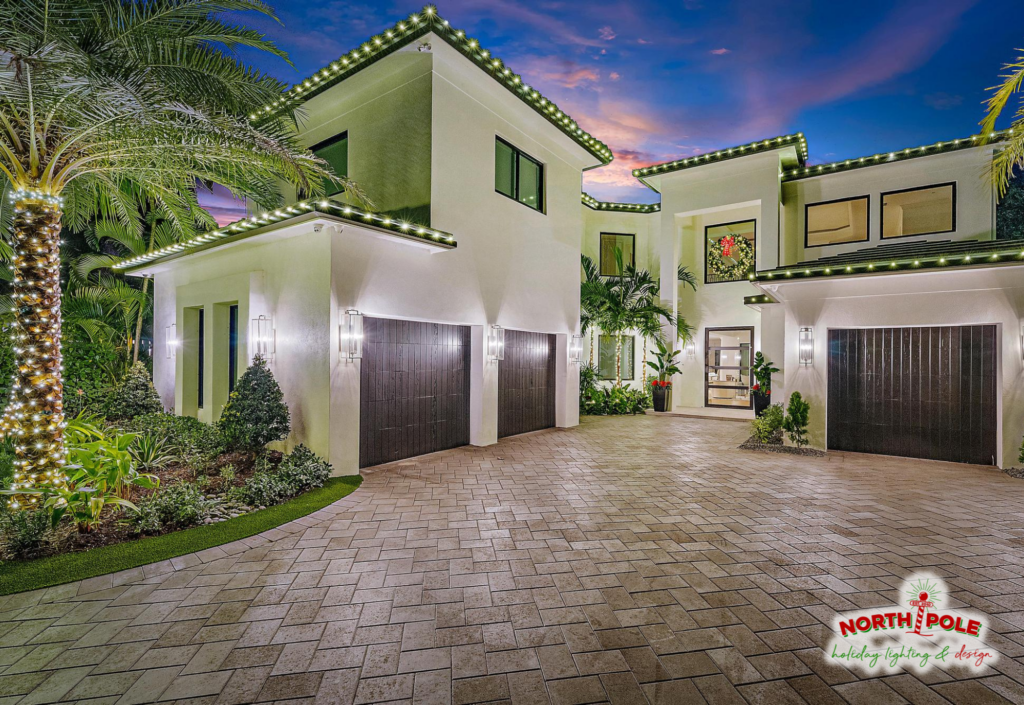 Permanent LED roofline lighting installation on a modern luxury estate in Palm Beach Gardens, featuring color-changing trim lights and a lit holiday wreath.