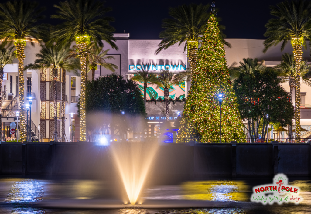 Large commercial holiday display at Downtown Palm Beach Gardens featuring a 36-foot tall decorated Christmas tree and warm white LED palm wraps.